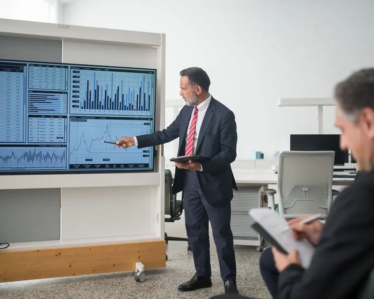 A finance professional presenting digital financial dashboards in a modern boardroom